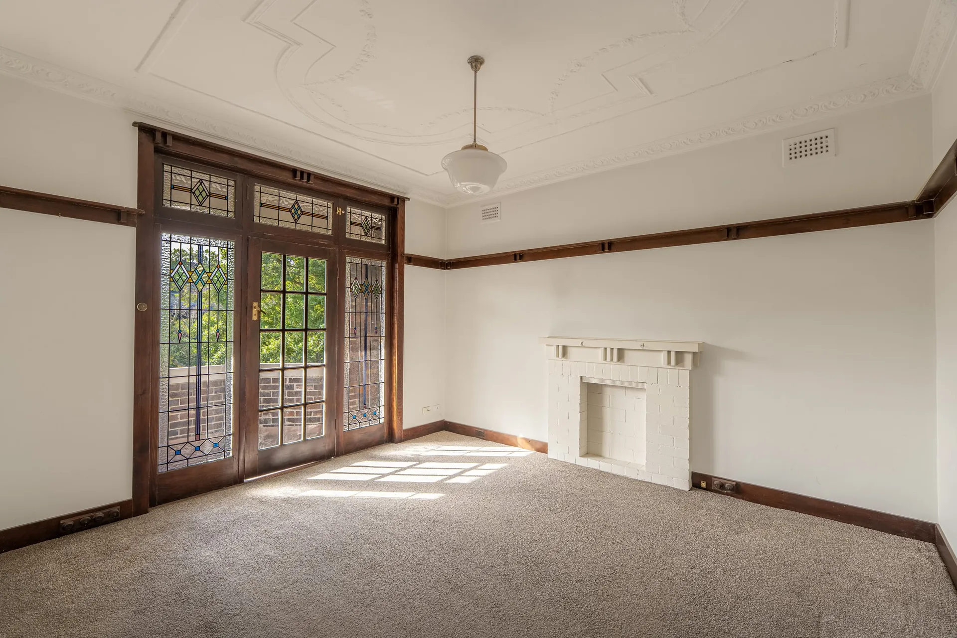 Randwick living room with stained-glass doors and fireplace